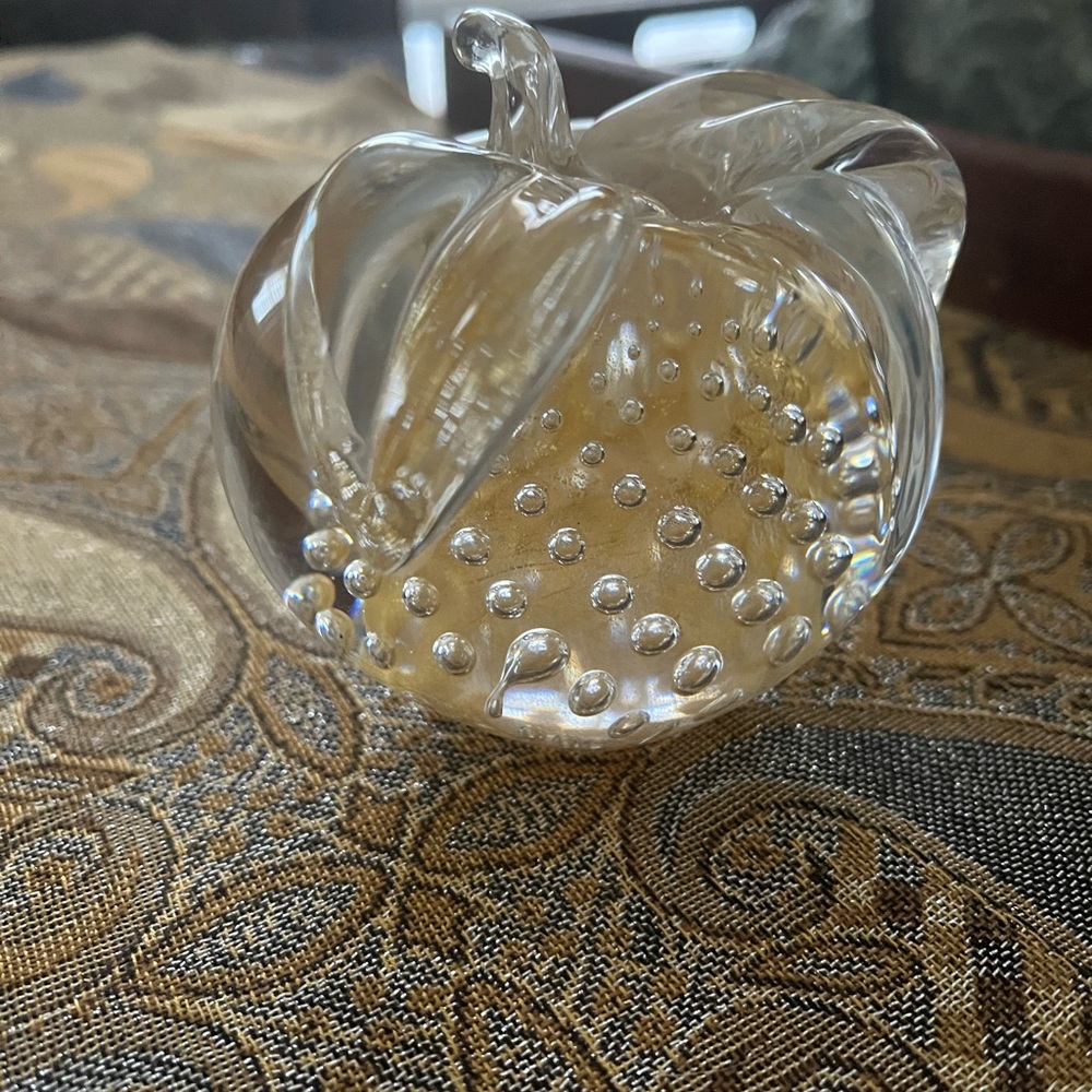 A glass apple with a gold bubble design inside